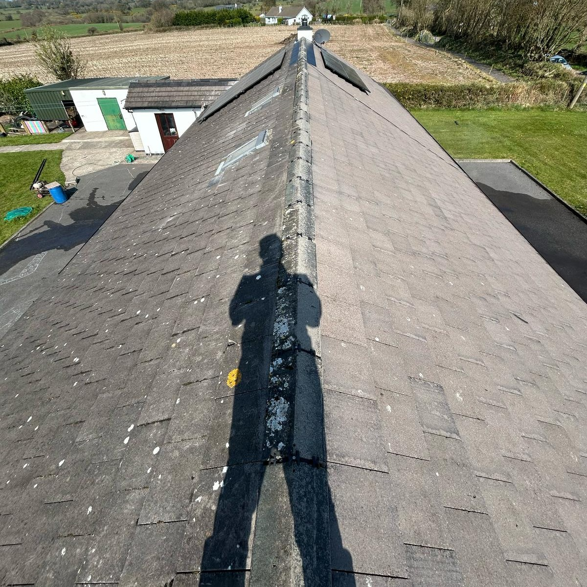 DPS Roofing crew member surveying a residential roof ridge