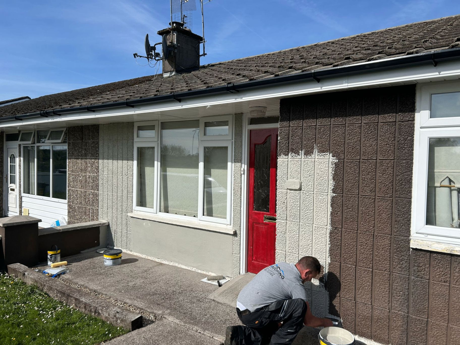 Front of a house during exterior painting and roofline work