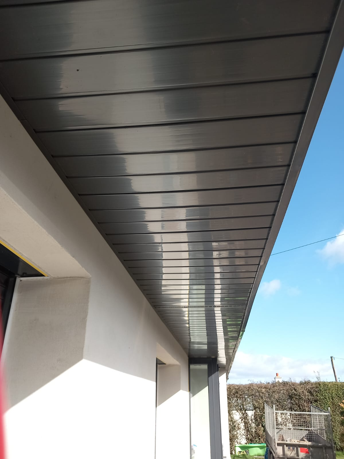 Close-up of newly installed dark grey soffit and fascia under the roofline